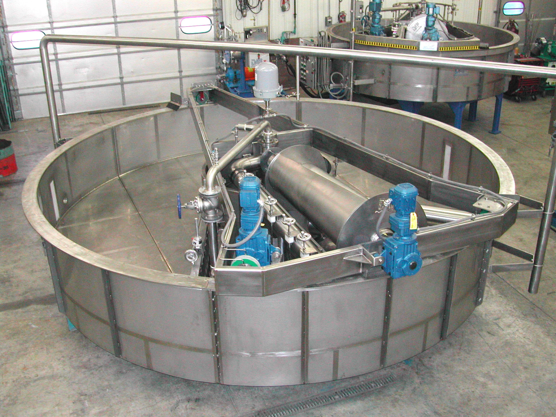 DAF Corp dissolved air flotation units being fabricated in the shop with stainless steel tanks, blue motors, and skimmer drums